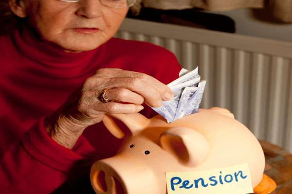 Figura di anziana signora intenta a riempire un salvadanaio con la scritta "pension"