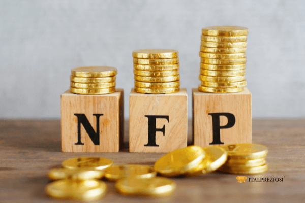 Dadi in legno compongono l'acronimo NFP (nonfarm payrolls). Attorno monete d'oro. Sopra i dadi altre monete a comporre una scala ascendente