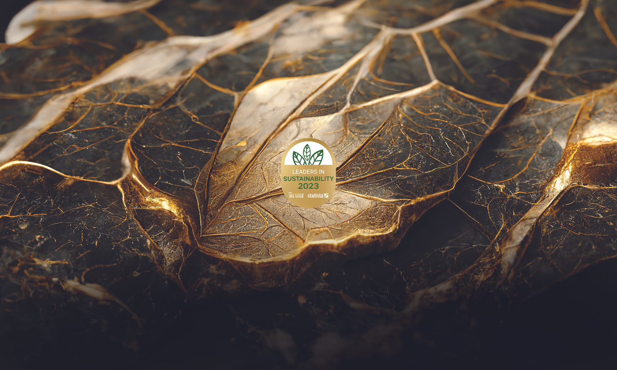 logo del premio "Leader della Sostenibilità 2023" ricevuto da Italpreziosi su un background di foglie autunnali